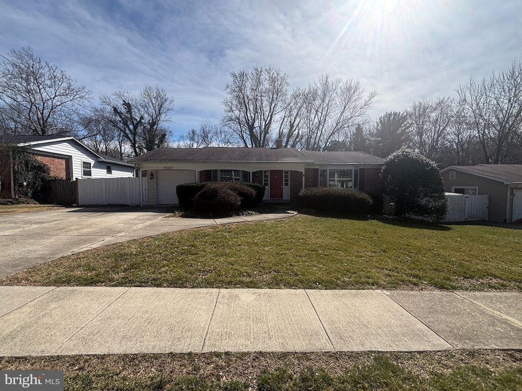 ranch-style house with an attached garage, concrete driveway, a front yard, and fence