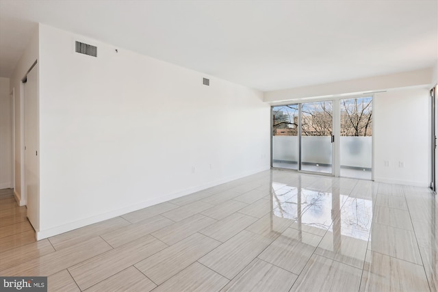 spare room featuring visible vents and baseboards