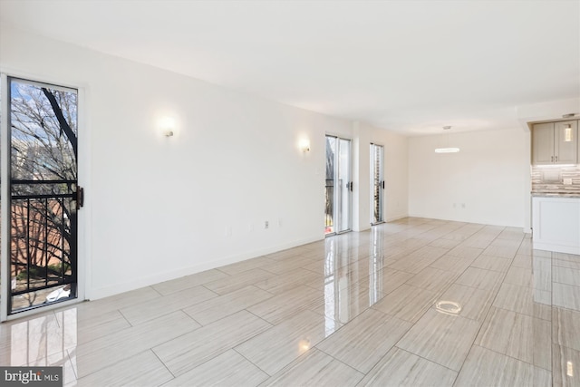 interior space with baseboards and a healthy amount of sunlight