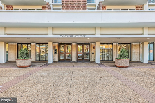 view of exterior entry featuring french doors and brick siding