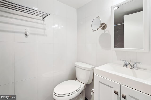 bathroom with decorative backsplash, toilet, tile walls, and vanity