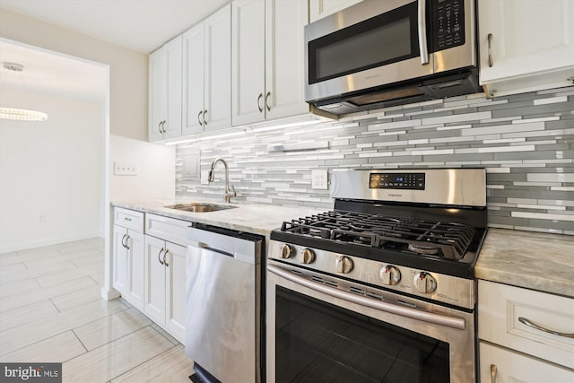 kitchen featuring a sink, white cabinets, tasteful backsplash, and stainless steel appliances