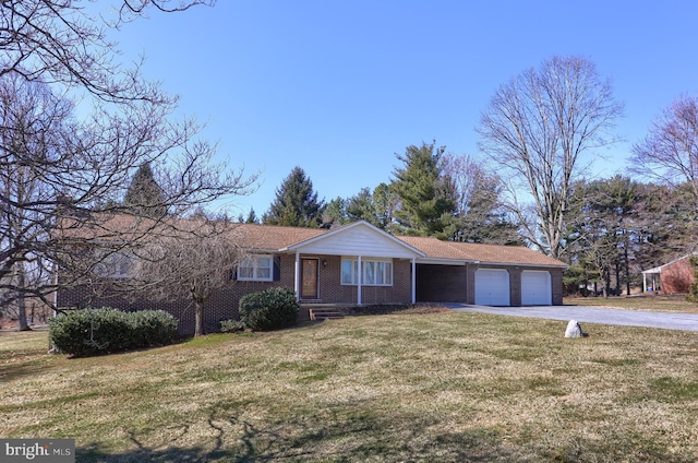 single story home with a front lawn, brick siding, a garage, and driveway