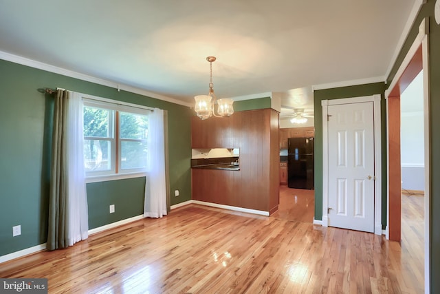 unfurnished dining area featuring an inviting chandelier, crown molding, baseboards, and light wood finished floors