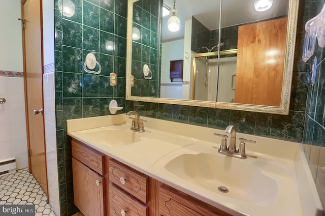 full bathroom with a sink, tile walls, a stall shower, and double vanity