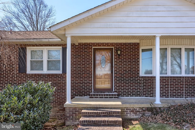 view of exterior entry featuring brick siding