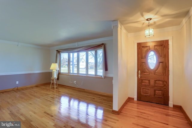 entryway featuring crown molding, baseboards, and light wood-type flooring