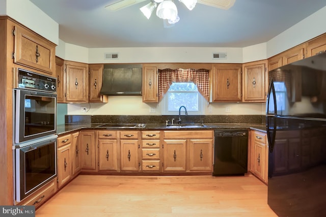 kitchen with visible vents, a sink, black appliances, extractor fan, and light wood-style floors