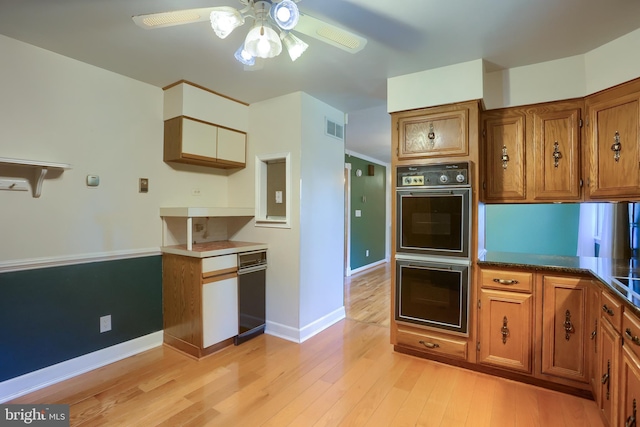 kitchen with multiple ovens, visible vents, brown cabinets, and light wood-style floors