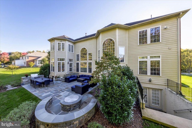 rear view of house with a yard, a patio, an outdoor living space with a fire pit, and entry steps