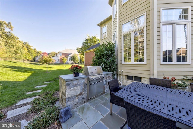 view of patio with area for grilling and a grill