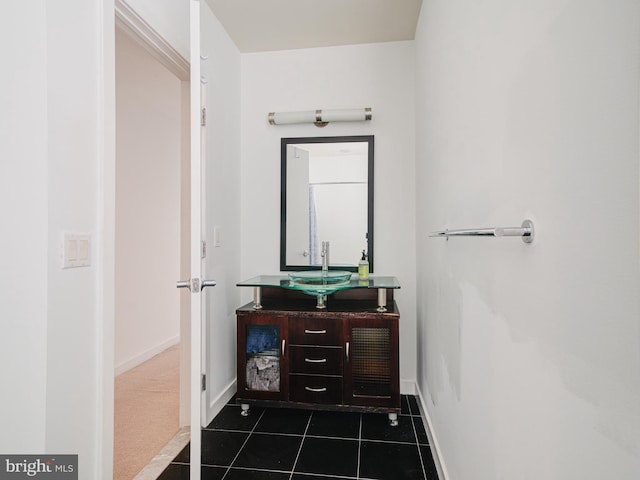 bathroom with baseboards, vanity, and tile patterned flooring