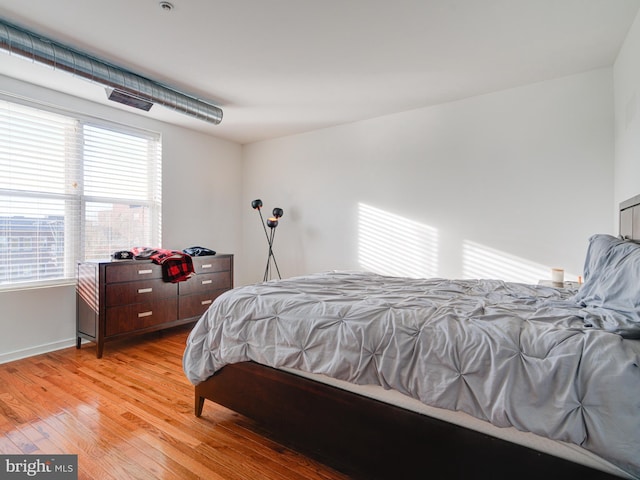 bedroom featuring baseboards and light wood finished floors