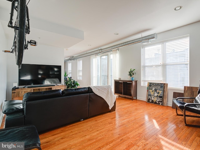 living area featuring recessed lighting, baseboards, and light wood finished floors