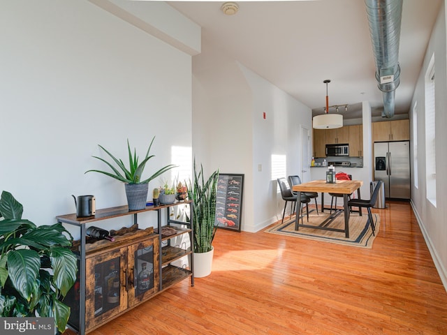 dining room featuring baseboards and light wood-style floors