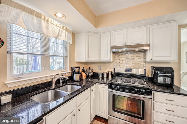 kitchen featuring white cabinetry, stainless steel range with gas stovetop, under cabinet range hood, and a sink