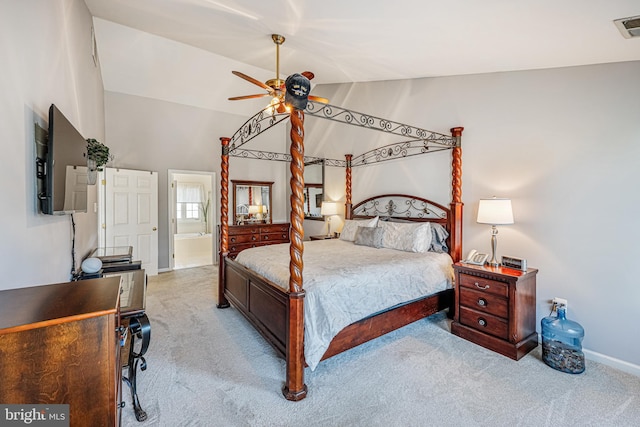 carpeted bedroom featuring visible vents, connected bathroom, ceiling fan, baseboards, and vaulted ceiling