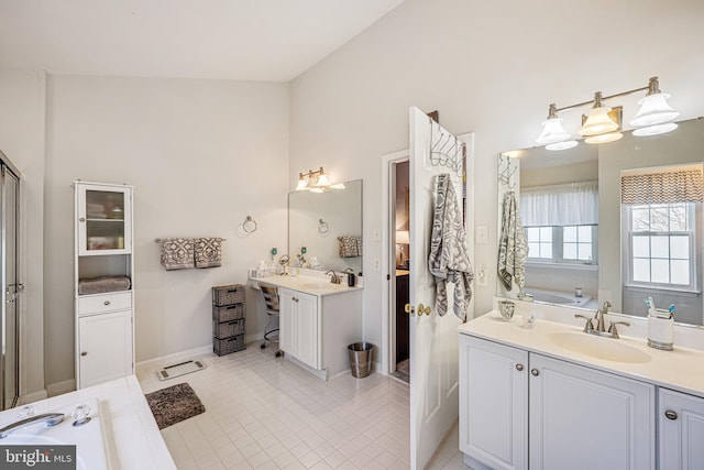 bathroom featuring tile patterned flooring, two vanities, a garden tub, and a sink