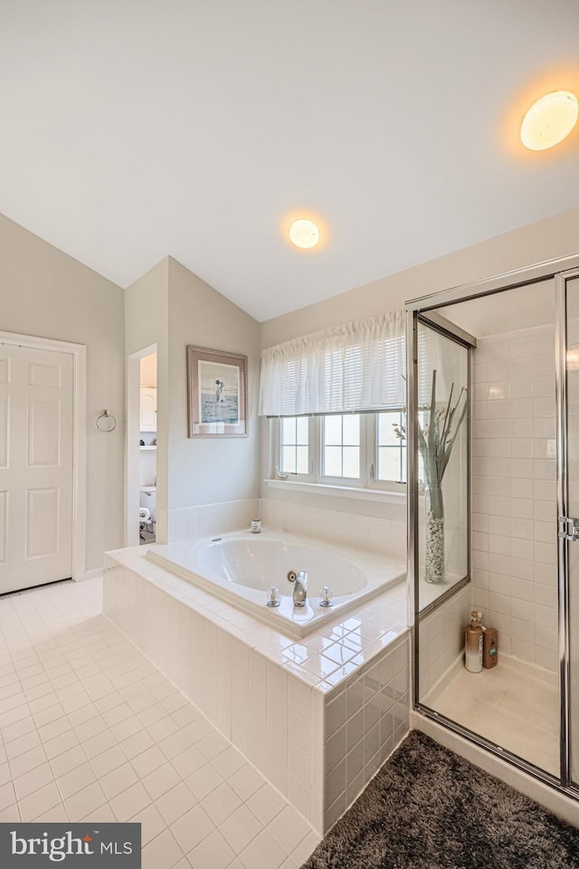 bathroom with a bath, a stall shower, and lofted ceiling