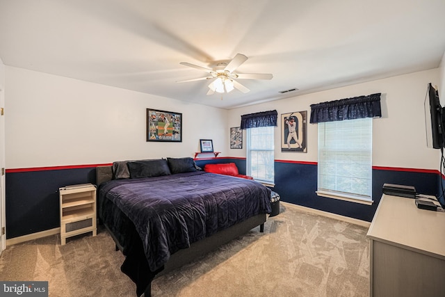 carpeted bedroom featuring a ceiling fan, baseboards, and visible vents