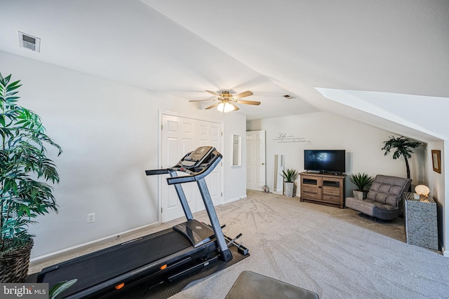 workout area featuring lofted ceiling with skylight, carpet flooring, and visible vents