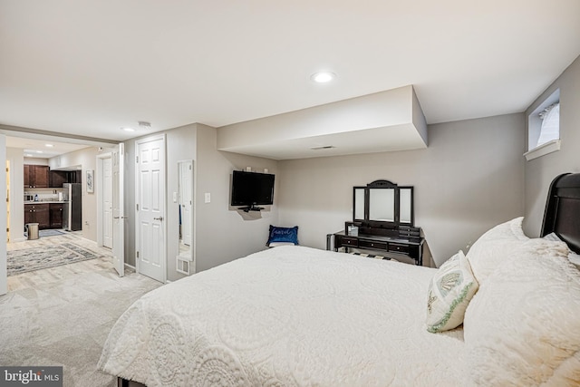 bedroom with recessed lighting, light colored carpet, freestanding refrigerator, and visible vents