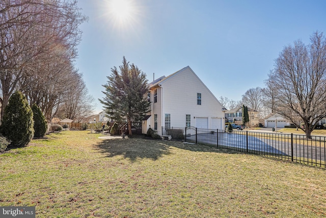 view of property exterior featuring an attached garage, driveway, a yard, and fence