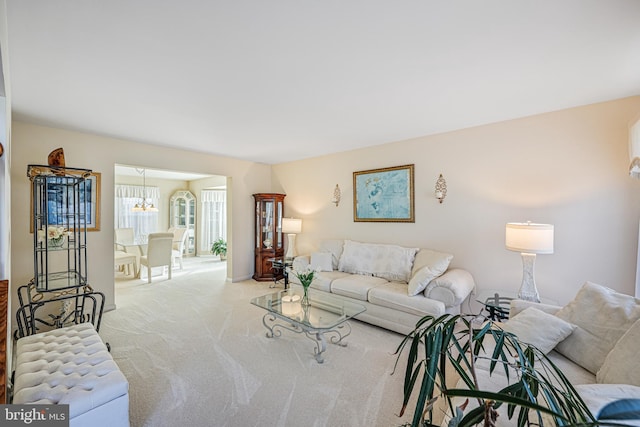 living area with an inviting chandelier and light carpet