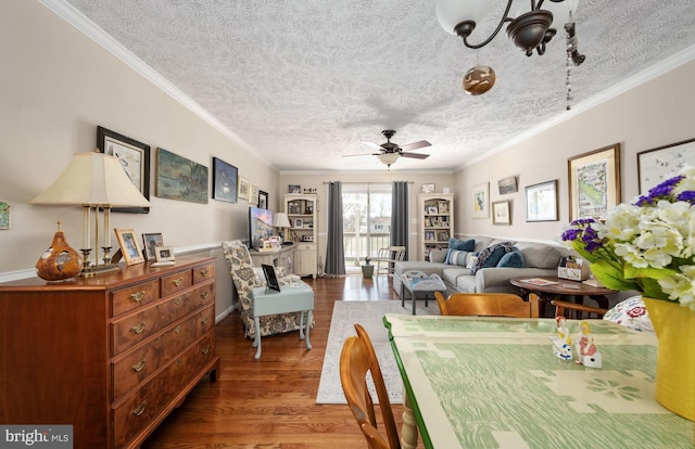 dining area with a textured ceiling, crown molding, wood finished floors, and ceiling fan