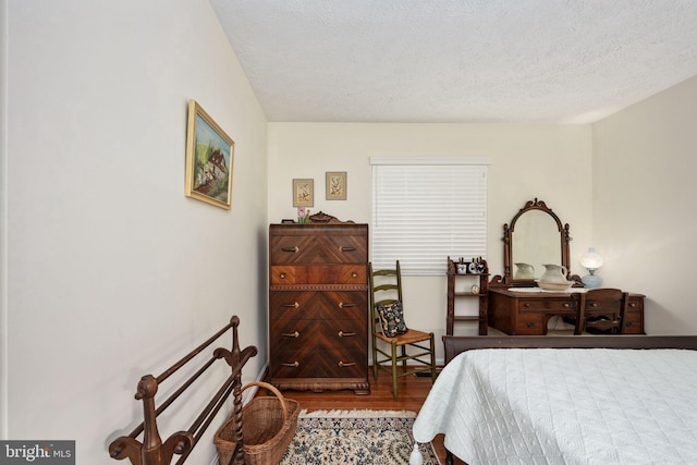 bedroom with wood finished floors and a textured ceiling