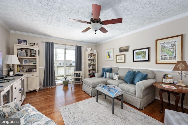 living area featuring a ceiling fan, crown molding, wood finished floors, and a textured ceiling