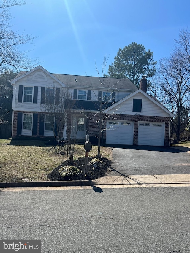 traditional-style home with aphalt driveway, brick siding, and a chimney