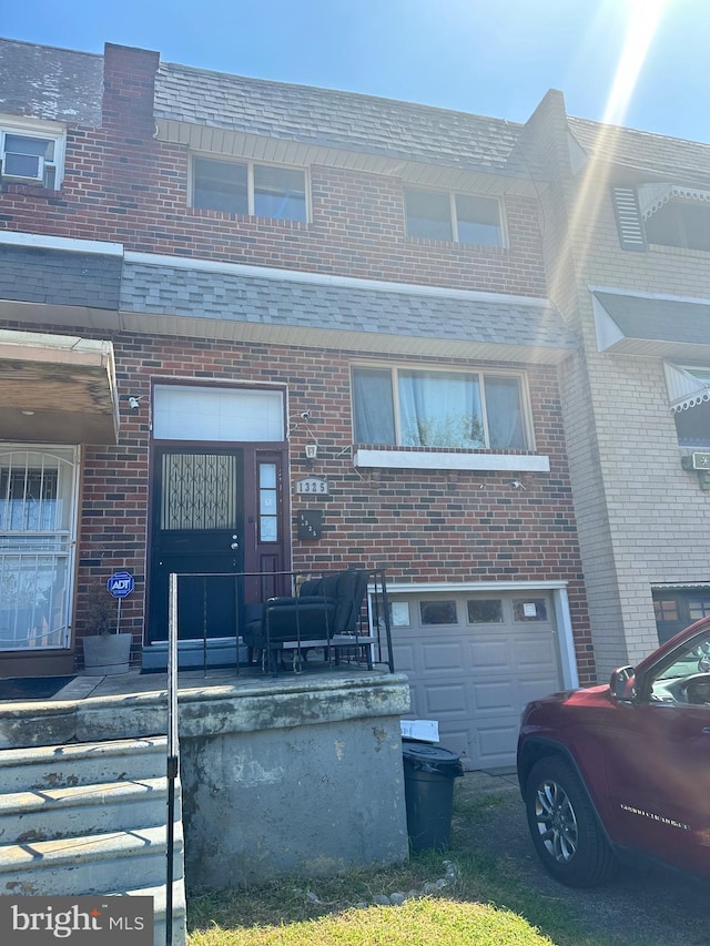 townhome / multi-family property featuring brick siding and an attached garage