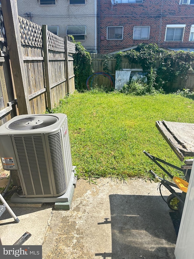 view of yard with central AC and fence