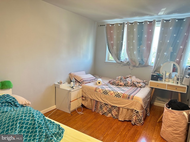 bedroom featuring baseboards and wood finished floors