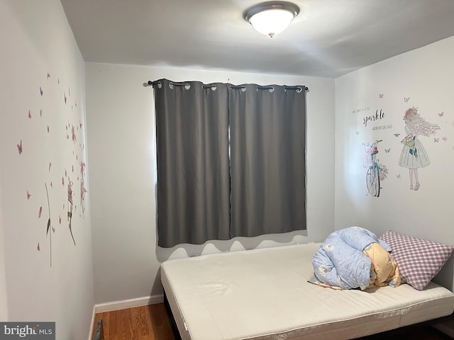 bedroom with baseboards and wood finished floors