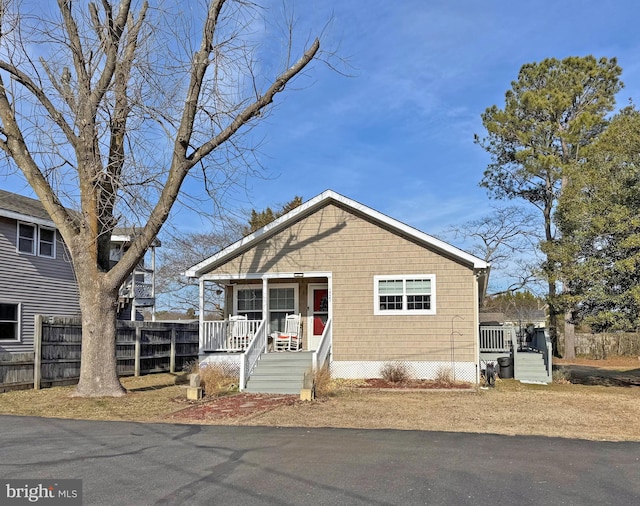 view of front of property featuring a porch and fence