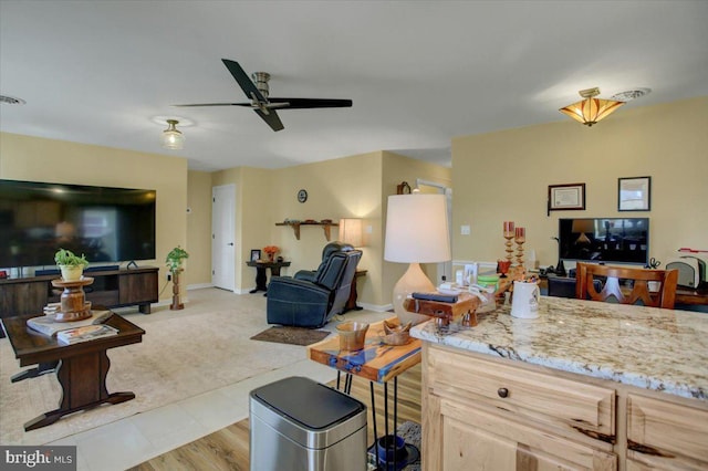 living room with baseboards and ceiling fan