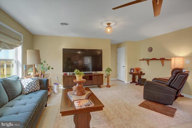 living area with visible vents, baseboards, and a ceiling fan