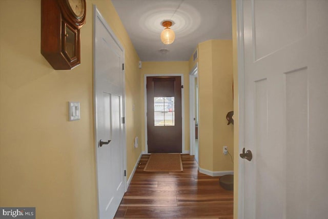 entryway with visible vents, baseboards, and dark wood finished floors