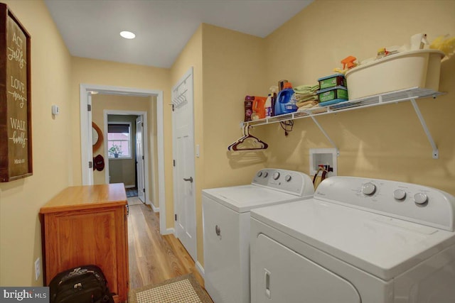 laundry room with laundry area, washing machine and dryer, light wood-type flooring, and baseboards