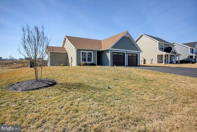 single story home featuring aphalt driveway, a garage, and a front lawn