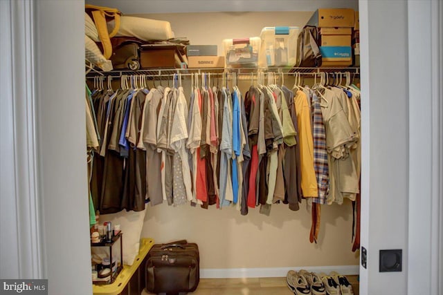 walk in closet with wood finished floors