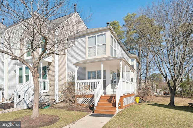 view of front of home with a porch and a front lawn