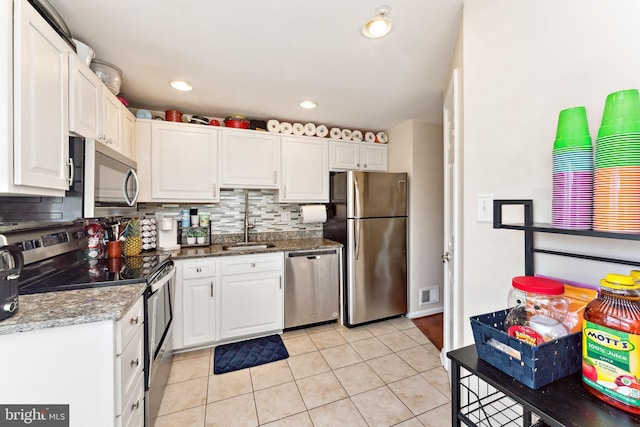 kitchen featuring visible vents, decorative backsplash, appliances with stainless steel finishes, white cabinetry, and a sink