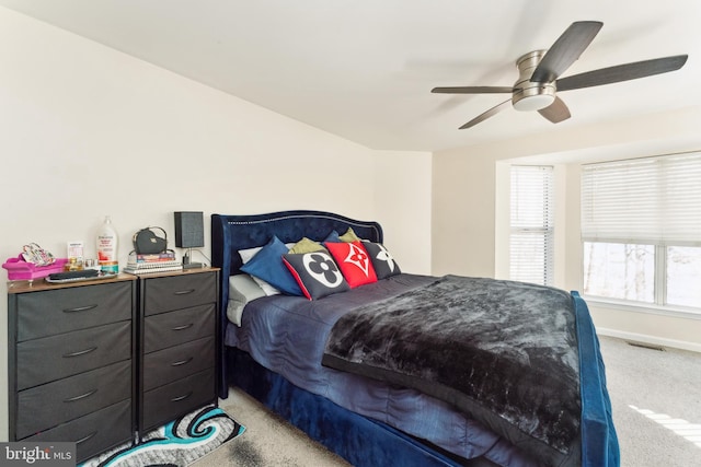 bedroom featuring a ceiling fan, visible vents, light colored carpet, and baseboards