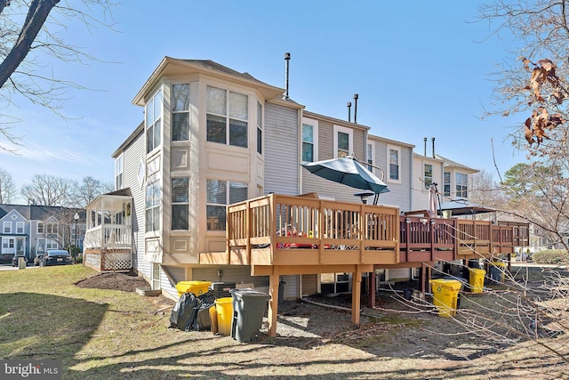 back of house with a wooden deck, a residential view, and a yard