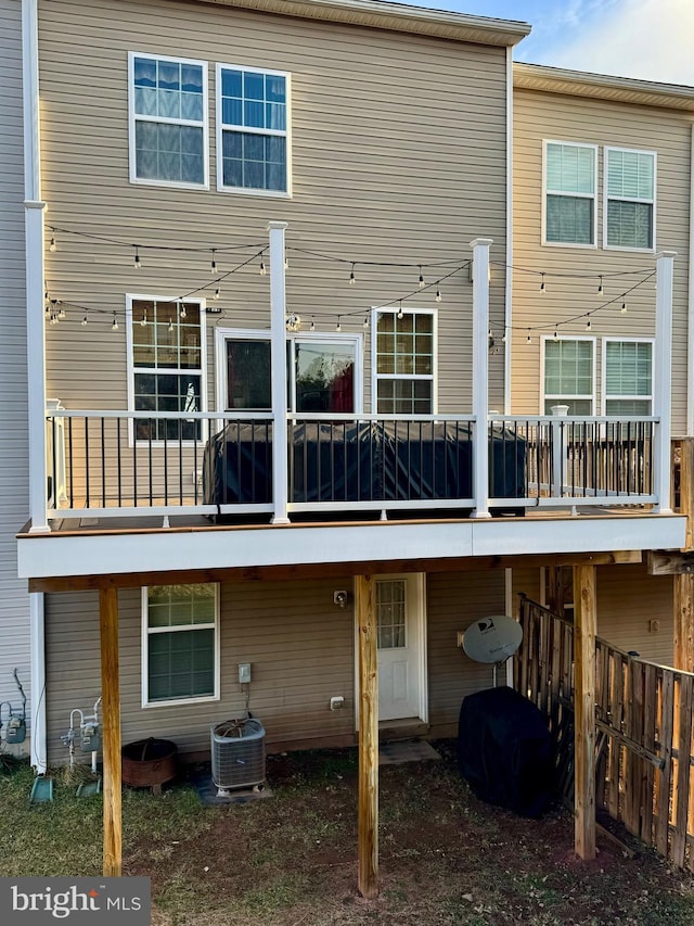 rear view of house featuring fence and central AC