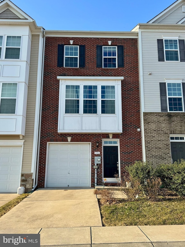 multi unit property featuring brick siding, an attached garage, and driveway