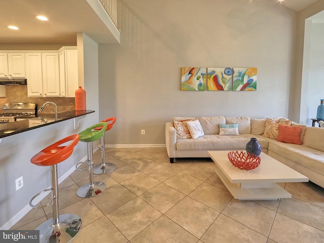 living area with light tile patterned floors, baseboards, and recessed lighting